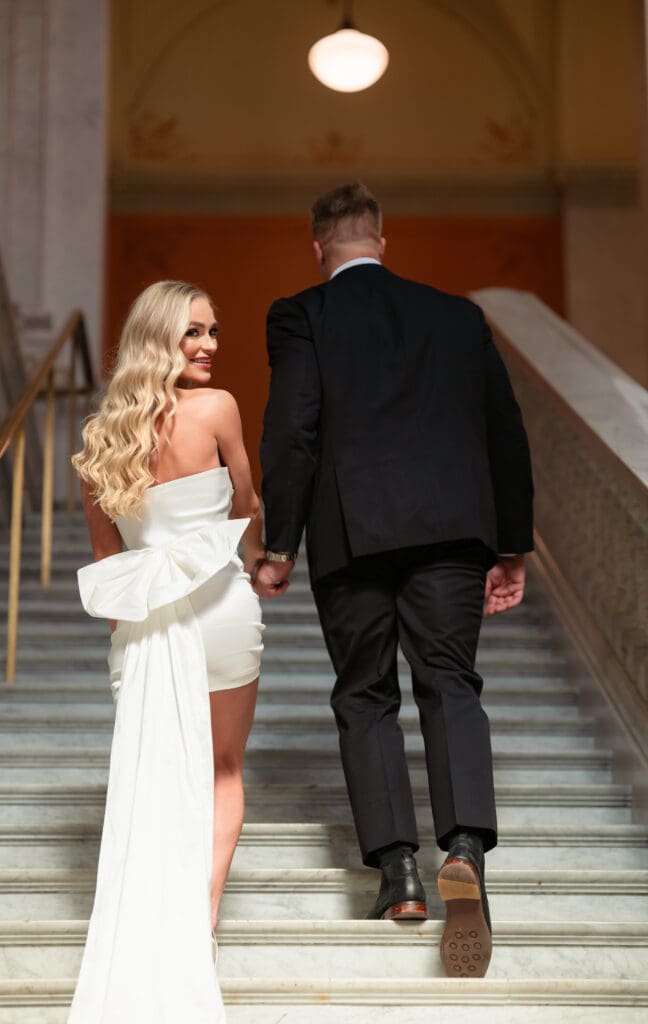 Bride looking over her shoulder walking up steps at The Ohio Statehouse