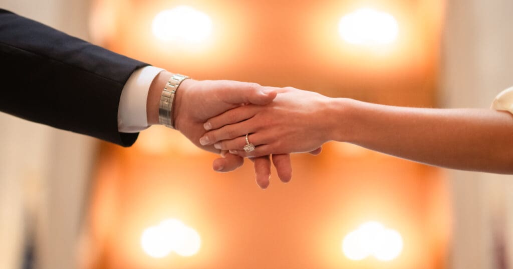 Close up of couples hands showcasing enagemnt ring in Ohio Statehouse Rotunda