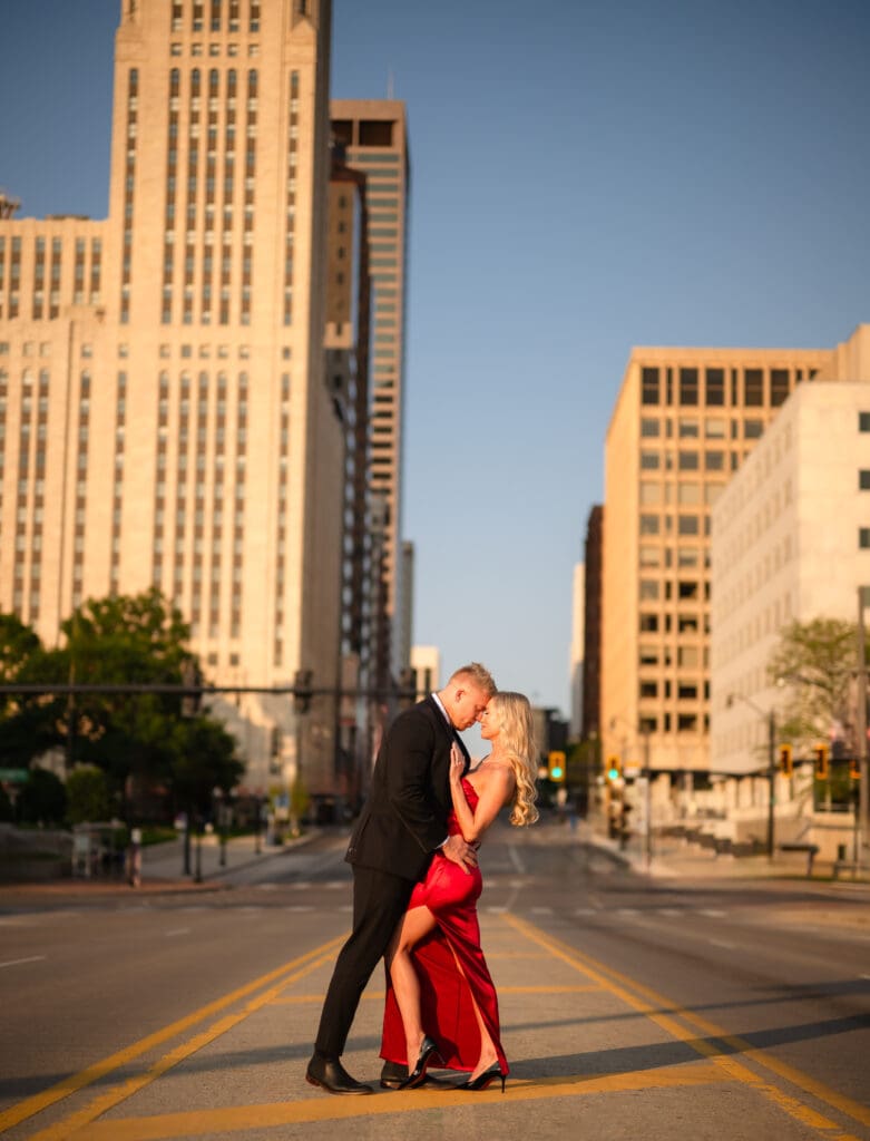 Bride and groom posing romantically with historic Columbus in the background