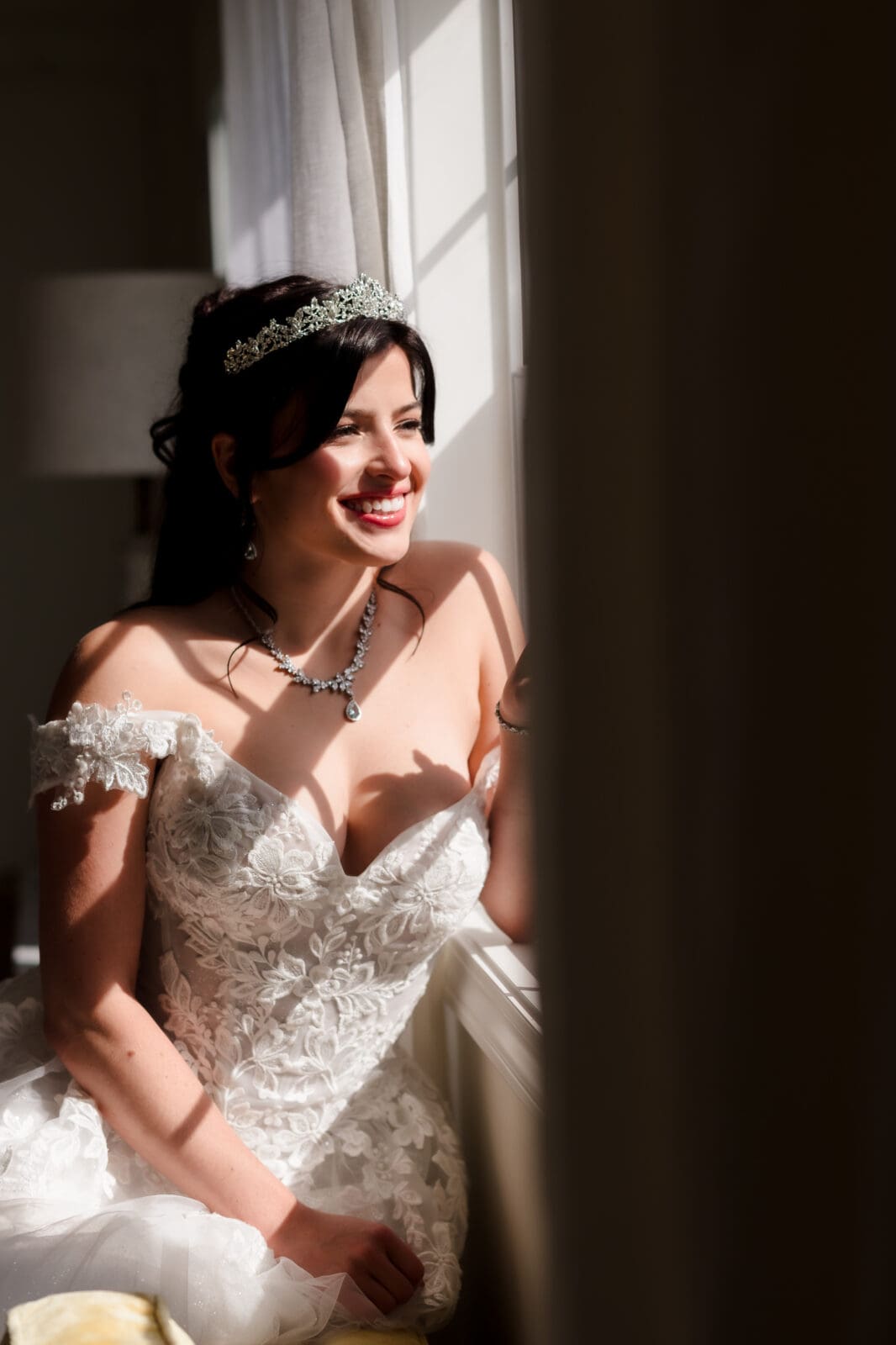 Aspen & Alston garden party wedding bride posing by the window in bridal suite with light on her face
