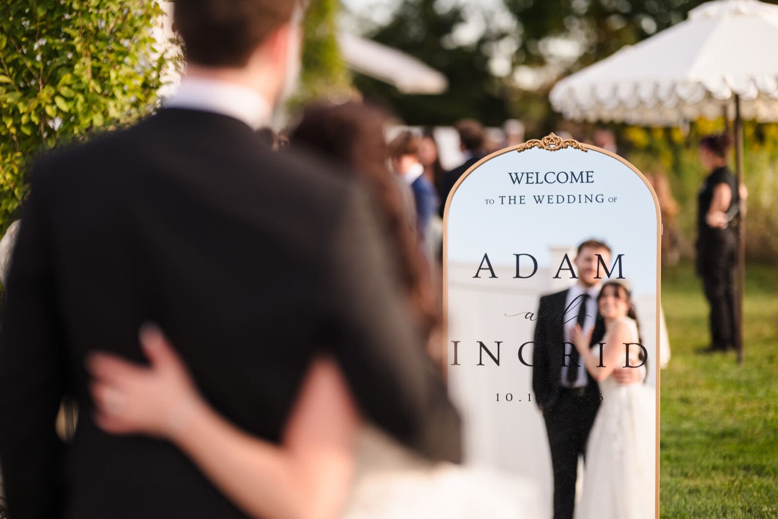 Intimate garden party Aspen & Alston wedding where couple looks in their welcome sign mirror for a reflection photo