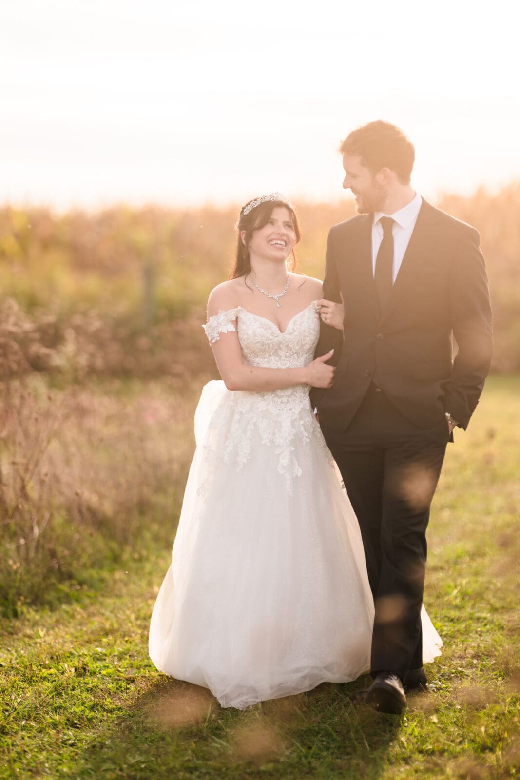 Timeless wedding photography at Aspen & Alston capturing romantic connection while couple is walking together in the field