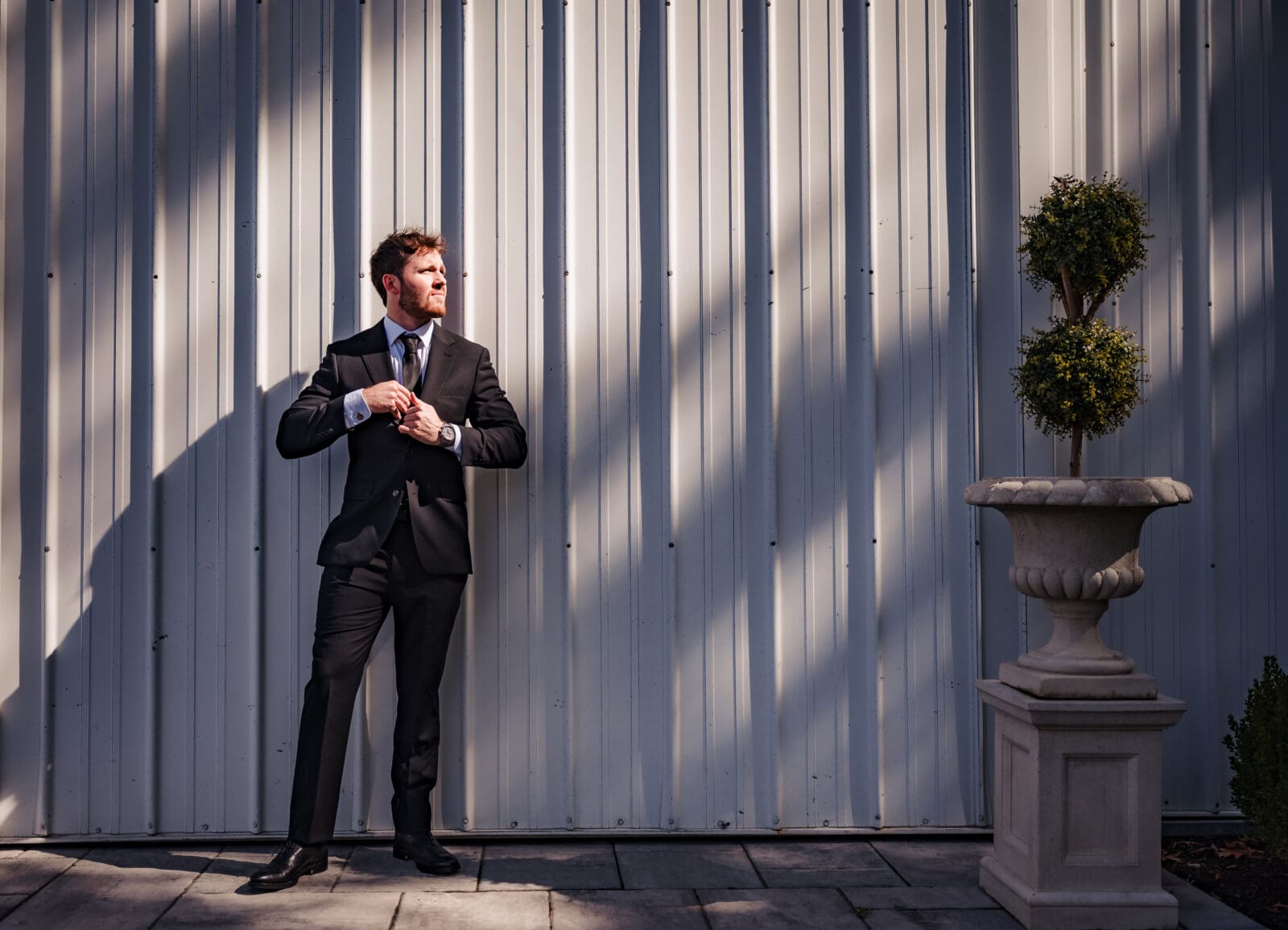 Intentional Aspen & Alston wedding groom portrait in dramatic shadows and light outside of reception space