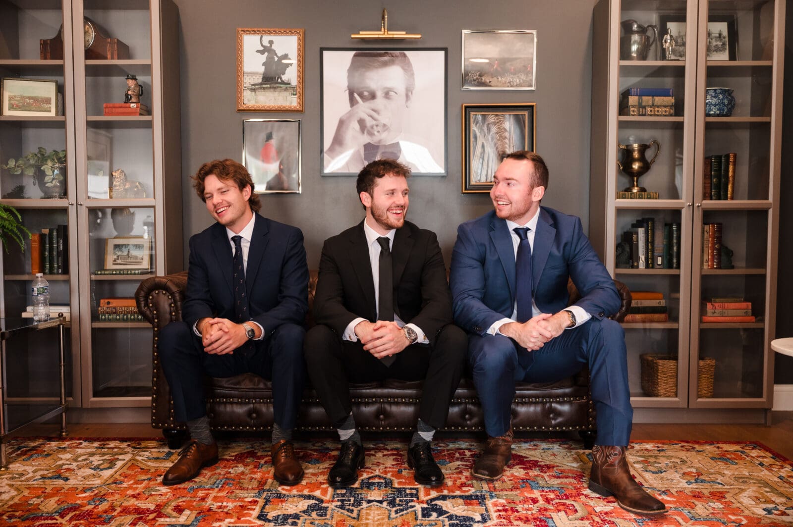 groom and brothers sitting in grooms suite laughing together at Aspen & Alston garden party wedding