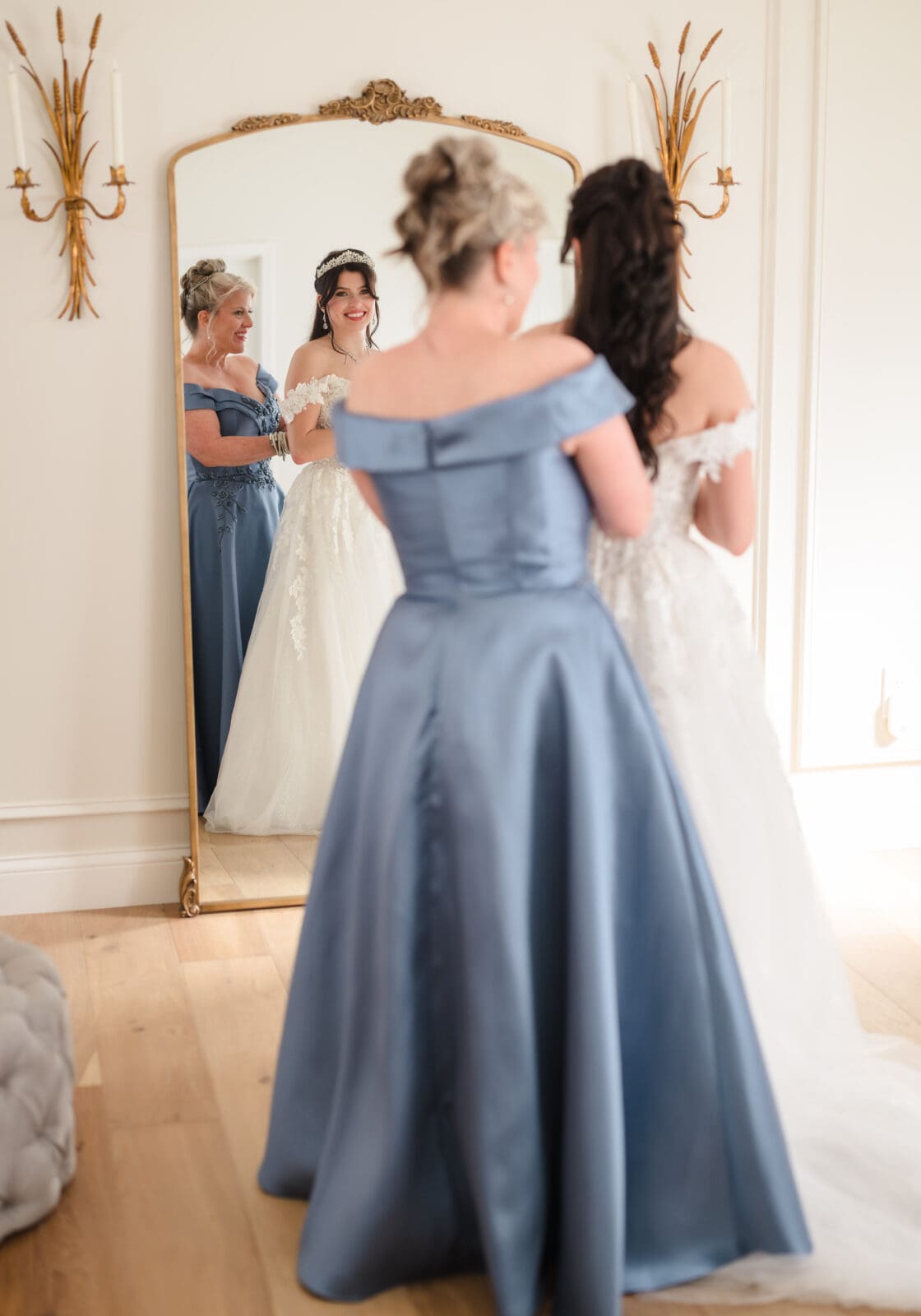 mother of the bride buttoning up brides wedding gown in getting ready space at Aspen & Alston wedding