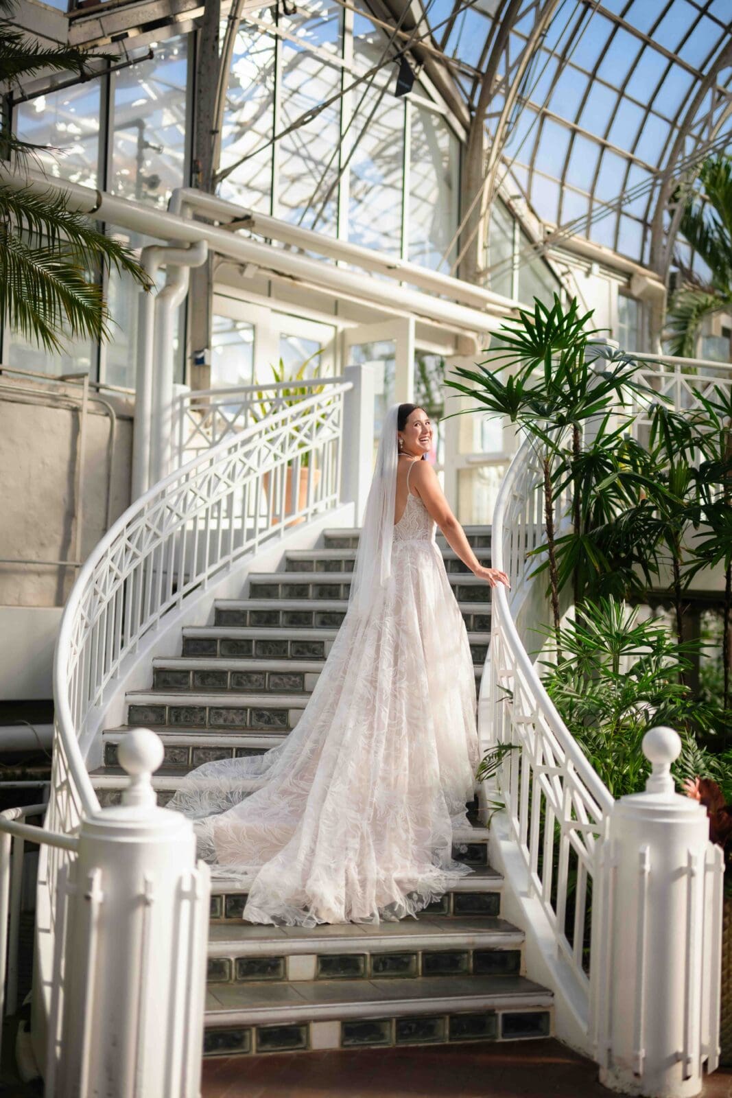 bride poses with flowing wedding dress down staircase in Palm House at Franklin Park Conservatory Columbus Ohio