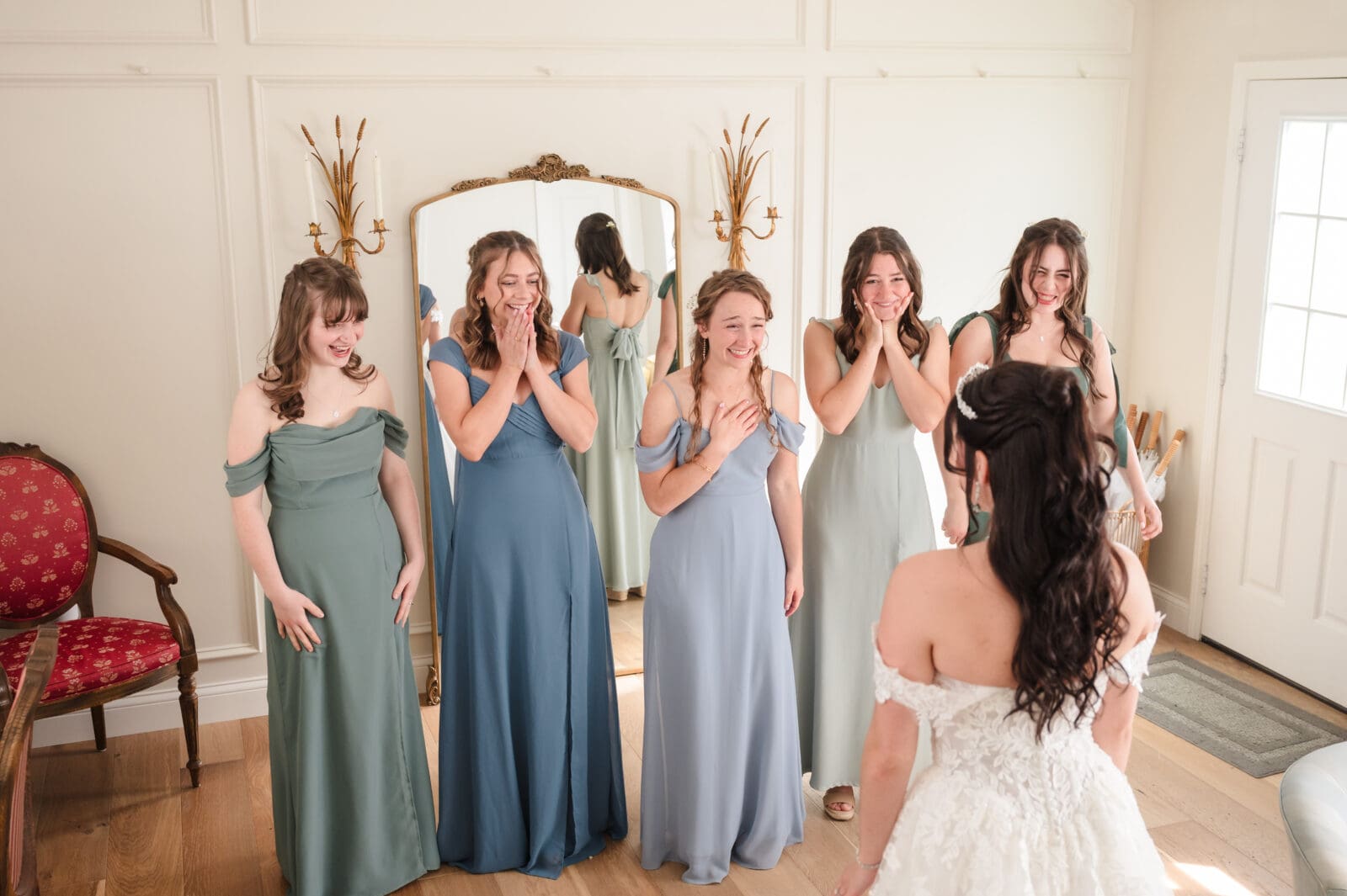 bridesmaids react with joy seeing bride in her wedding dress for the first time