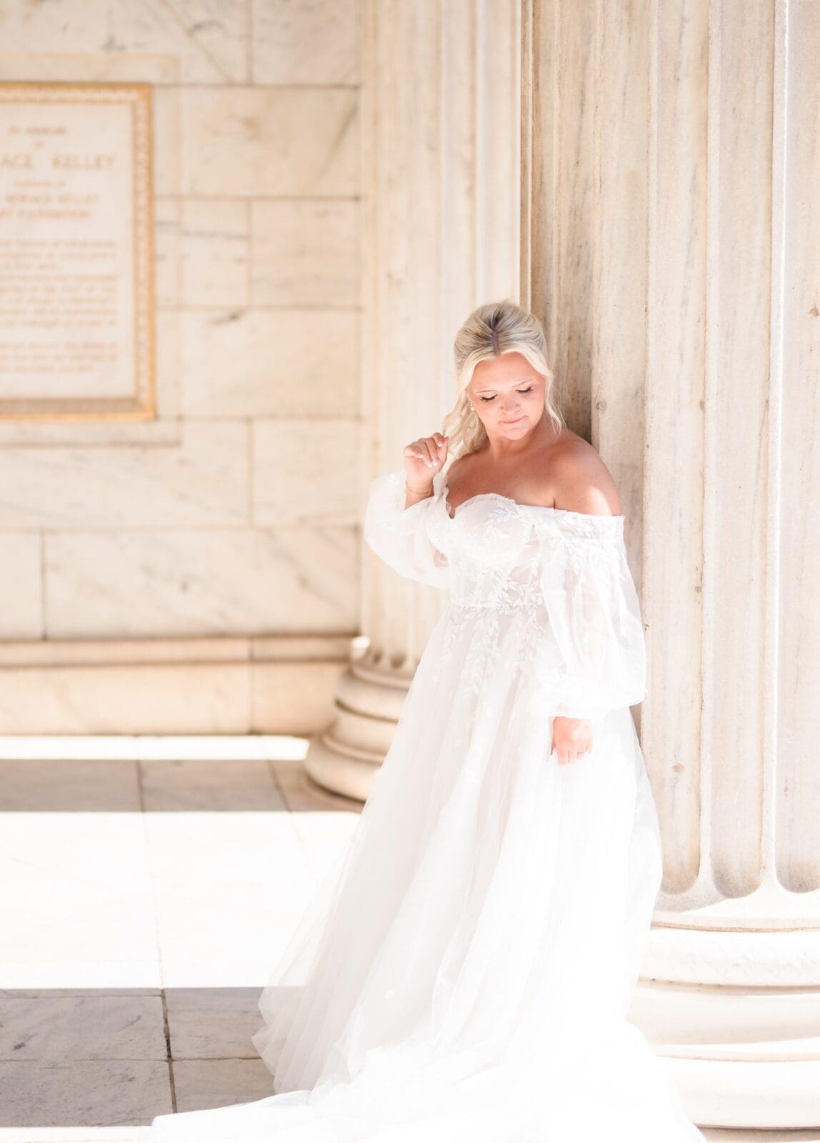 Bride leaning on pillar for beautiful bridal portrait in wedding dress outside of Cleveland Art Museum