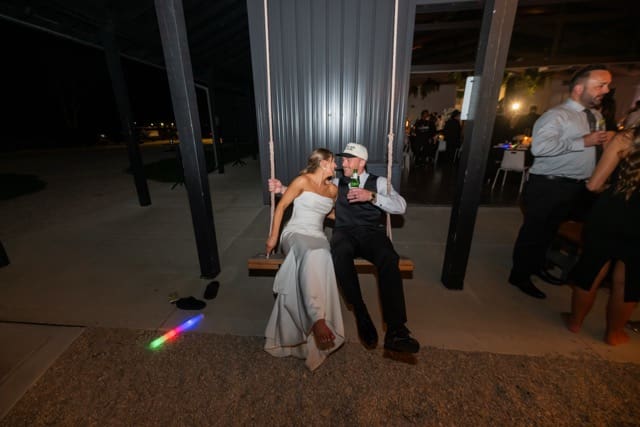 Couple swings on swing just outside reception space at Retreat 21