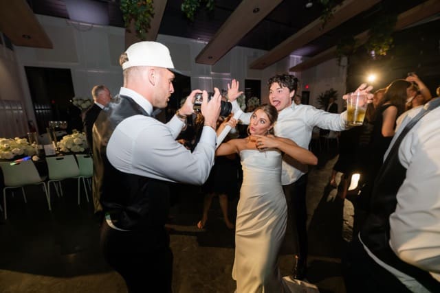 Groom records bride on video camera while on the dance floor at their Retreat 21 wedding