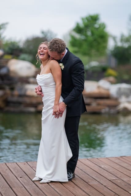 Groom making bride laugh outdoors by waterfall at Retreat 21