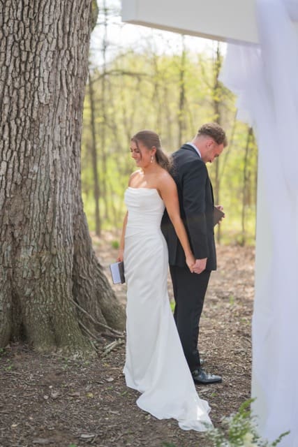 Bride laughing as groom shares thoughtful vows during their first touch at ceremony space of Retreat 21