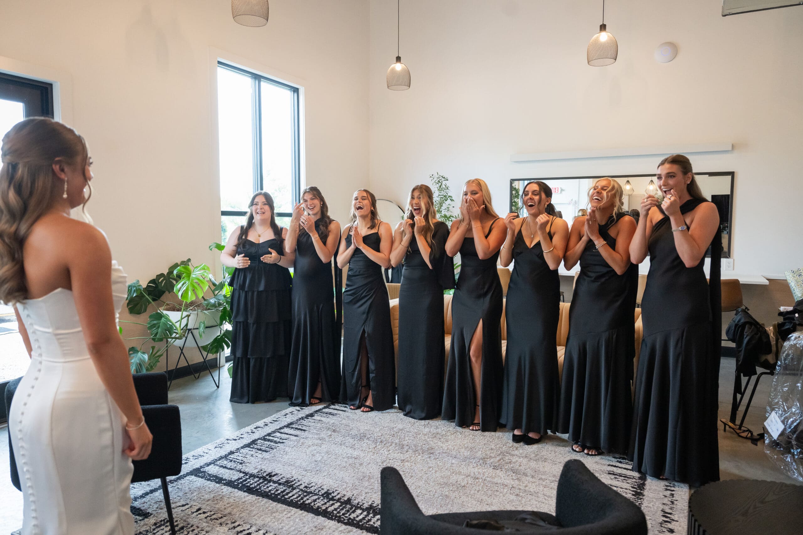 Bridesmaids joyful reaction to seeing bride in her wedding dress for the first time 