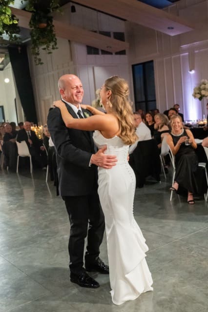 Father of the bride smiling at his daughter as he dances with her at Retreat 21