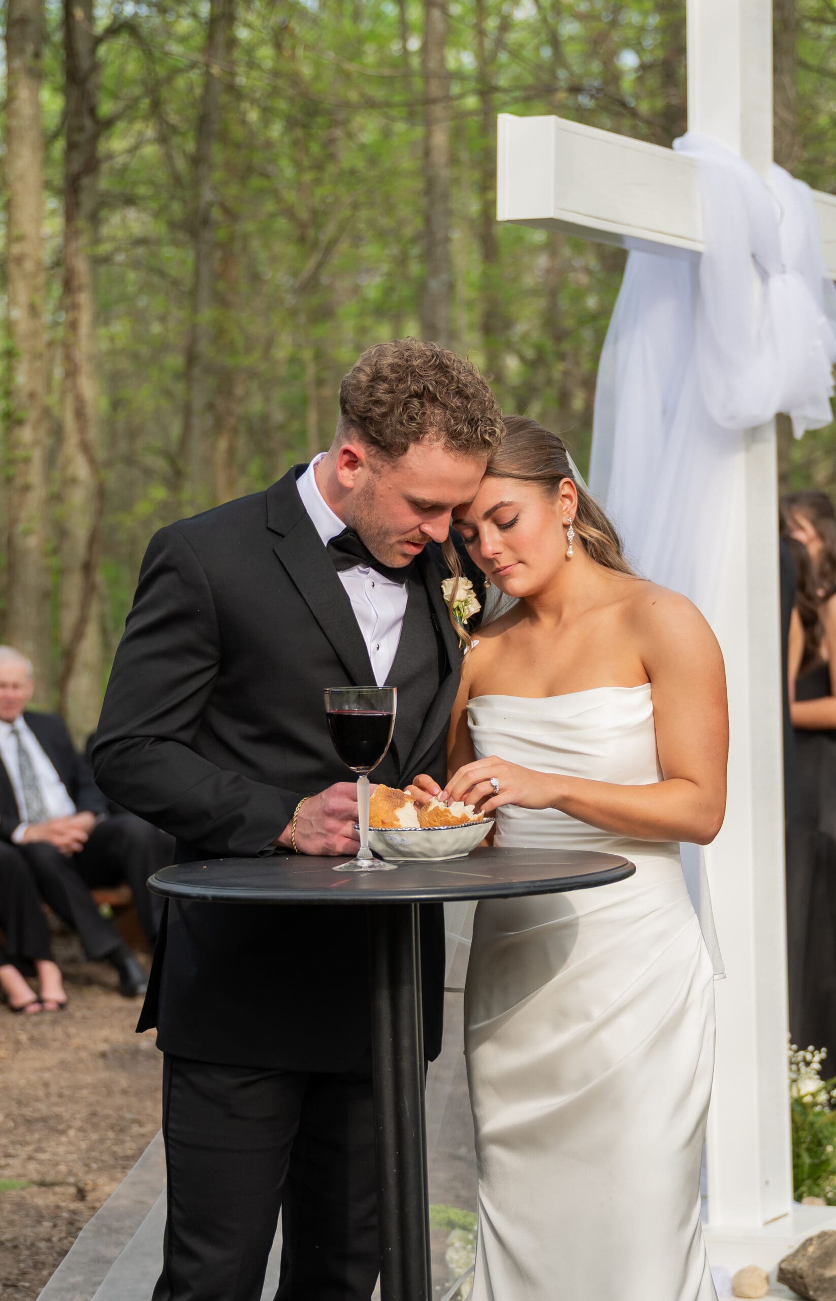 Bride and groom praying together during communion at their Retreat 21 wedding ceremony