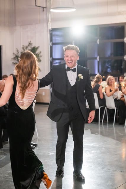 Groom laughing with his mom as they dance together at Retreat 21