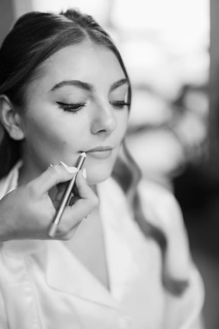 Close up of bride getting makeup done on wedding day at Retreat 21