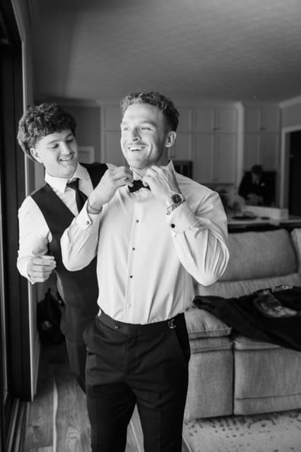 Grooms brother helping him get ready in groom getting ready area at Retreat 21