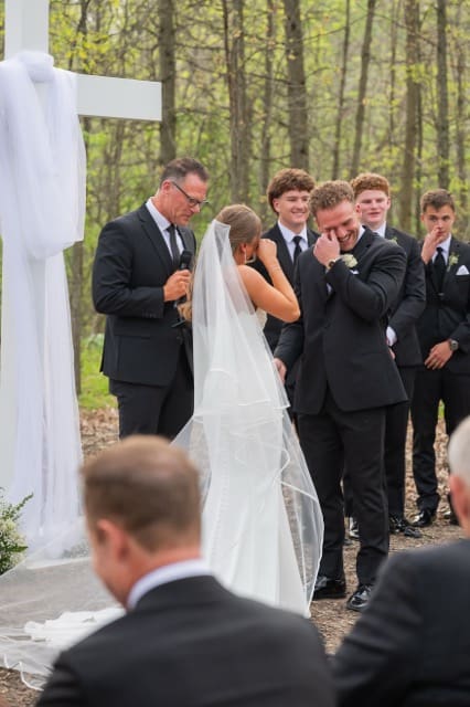 both bride and groom laughing and wiping away tears during their wedding ceremony at Retreat 21